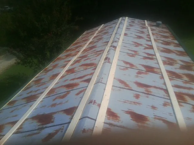 Rusted metal roof panels with new wood purlins before replacement — Storm Damage Roof Repair in Minot by Roofing Brothers